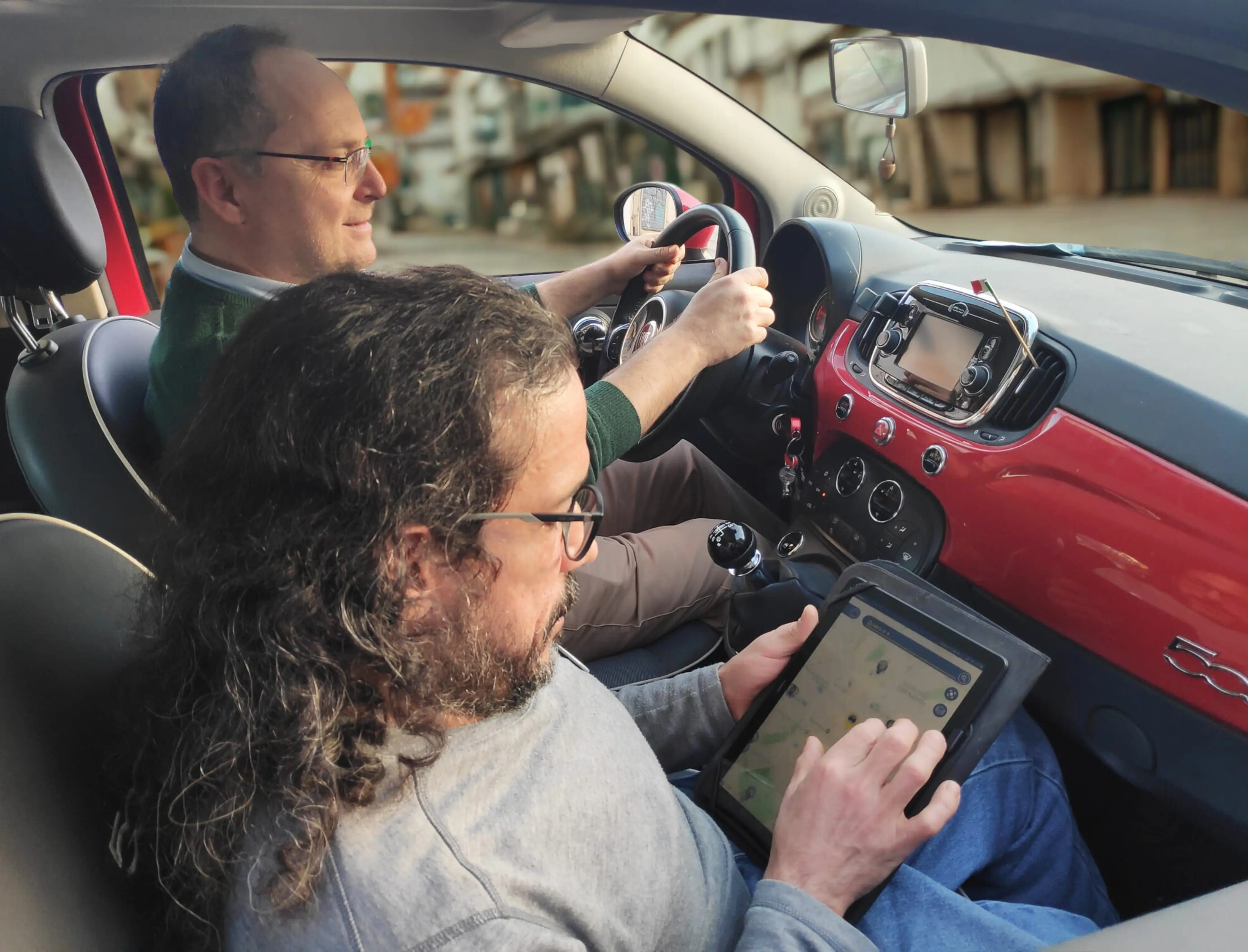 President Carlo demonstrating the functionality of the Spot4Dis App to a companion inside a moving vehicle